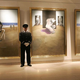 An art jail guard watches over three prisoners.